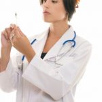 Doctor or nurse with medical syringe