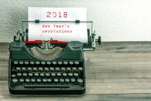 Typewriter with white paper page on wooden table. sample text 2016 New Year's Resolutions. vintage style toned picture