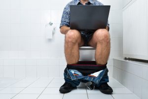 Man In Toilet Using Laptop