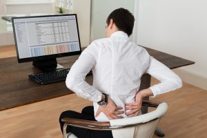Businessman Suffering From Backache At Desk