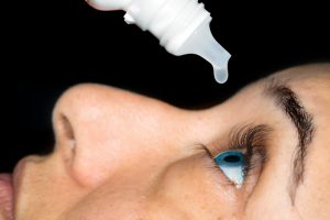 Person Pouring Drops In Eyes With Eyedropper.