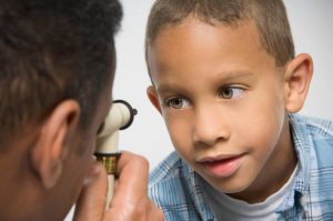 African boy having eyes examined by doctor