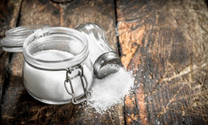 Salt in a glass jar. On wooden background.