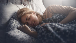 Attractive blonde woman peacefully sleeping. Side view. Horizontal.
