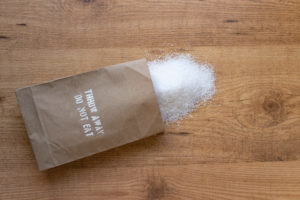 Salt in the paper pack on the table. "Throw away, do not eat" added salt intake health warning on the packet.