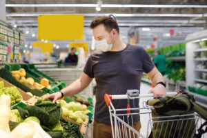 Man wearing disposable medical mask shopping in supermarket during coronavirus pneumonia outbreak. Protection and prevent measures while epidemic time.