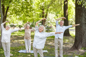 Group of old people doing qigong exercise outdoors stock photo