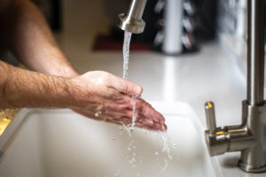 Close up of hands being washed in sink