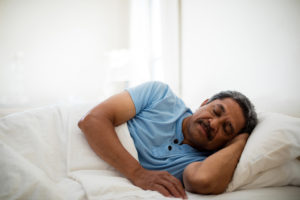 Senior man resting on bed in bedroom at home