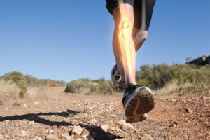 Digital composite of Highlighted leg bones of jogging man