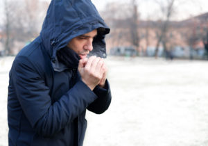 Man breathing on his hands to keep them warm