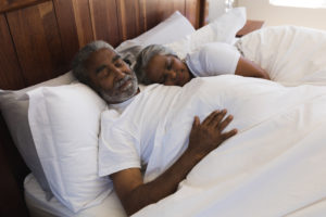 Close-up of a senior African American couple sleeping together in bedroom at home
