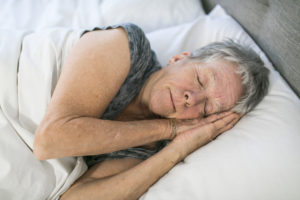 A Senior aged woman on bed at home feeling sad