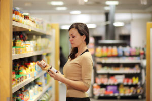 Women choosing a dairy products at supermarket. Reading product information