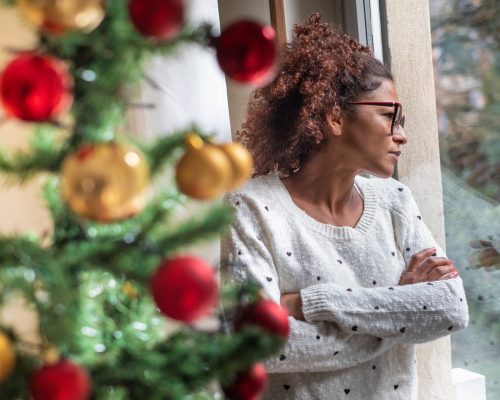 Pensive young black woman celebrating Christmas alone