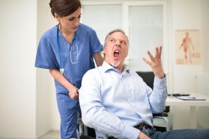 Portrait of a disabled patient screaming to a nurse
