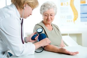 Female doctor measuring blood pressure of senior women