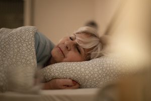 Mature woman lying on the bed and sleeping at night.