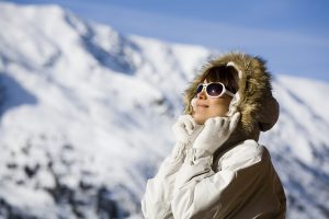 portrait of a woman with sunglasses on a terrace in the snowy mountains