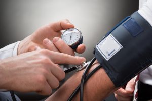 Close-up Of A Doctor's Hand Checking Blood Pressure Of A Patient