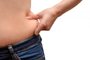 Close up of woman with excessive belly fat isolated on white background. Weight loss concept, overweight