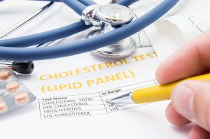General practitioner checks cholesterol levels in patient test results on blood lipids. Statin pills, stethoscope, cholesterol test and hand of doctor, pointing to increasing its level in concept