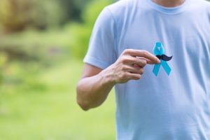 November Prostate Cancer Awareness month, adult Man holding Blue Ribbon with mustache for supporting people living and illness. Healthcare, International men, Father and World cancer day concept