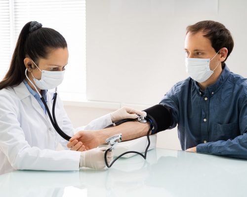Doctor Checking High Blood Pressure In Face Mask