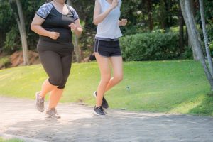 blurred motion of two women exercising by jogging in the park, they are running for health and fitness.