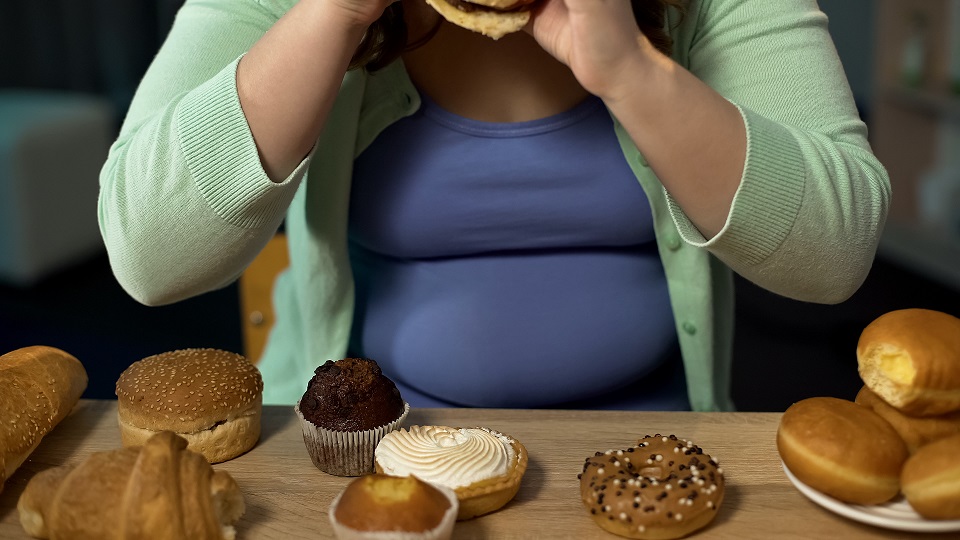 Overweight woman consuming too much bakery, eating stress with unhealthy sweets