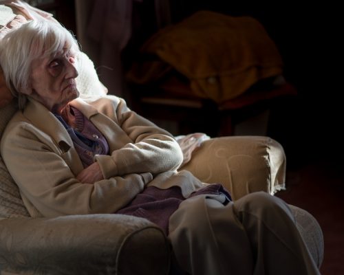 A ninety year old lady is covered in an insulating blanket to try and stay warm and is unable to leave her house unaided as she is registered blind and frail.