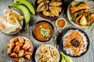 West african food concept. Traditional Wset African dishes assortment - peanut soup, jollof rice, grilled chicken wings, dry fried bananas plantains, nigerian chicken kebabs, meat pies, top view