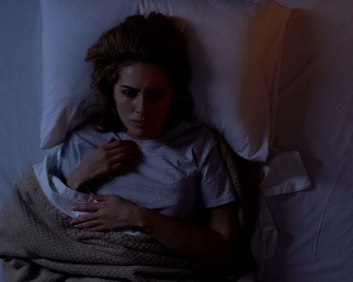 Annoyed woman suffering insomnia at night, uncomfortable sleeping conditions