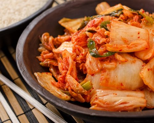 A bowl of traditional Korean napa kimchi with white rice.