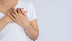 woman with chest pain and suffering health and medical concepts