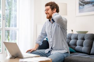 Young guy suffering from backache working from home
