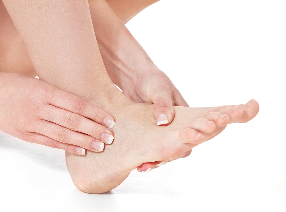 Female person massaging her feet. All on white background.