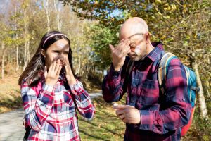 Father and teenage daughter applying sunscreen before hiking on a sunny autumn day. Concept of protecting the skin at any age and season (Father and teenage daughter applying sunscreen before hiking on a sunny autumn day. Concept of protecting the ski