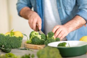 A man preparing a healthy dinner of baked broccoli. Healthy food concept