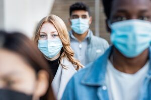 Authentic shot of multiracial people in the city wearing face mask and walking on the pavement commuting to work - Lifestyle and health issues concepts