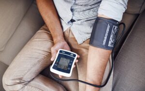 Closeup shot of an unrecognizable man monitoring his blood pressure levels with a blood pressure monitor at home
