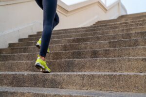 Confidence Hispanic woman in sportswear running up the stairway in the city. Healthy wellness female athlete enjoy outdoor lifestyle sport training workout exercise fitness jogging in summer