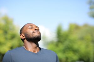 Man with black skin breathing in nature