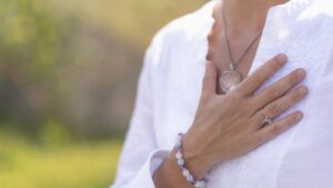 Gratefulness – Woman expressing gratitude with hands. Close up image of female hands in prayer position outdoor. Self-care practice for wellbeing