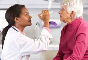 Female Doctor Examining Senior Female Patient's Eyes