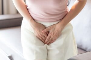 Woman having painful stomach ache or menstrual cramps. Chronic gastritis. Abdomen bloating concept.