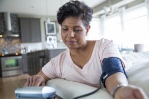 Woman checking blood pressure in living room